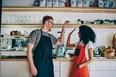 diverse male and female employees in aprons collaborating on successful startup